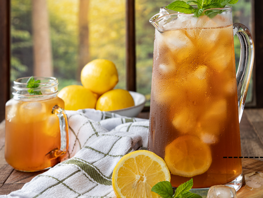 pitcher of sun tea with citrus on table in sun